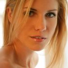 Hermosa rubia posando eróticamente con su cuerpo desnudo