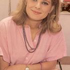 Mildred Roper posando sonriente con su blusa rosa
