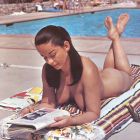 Tomando el sol en topless leyendo una revista